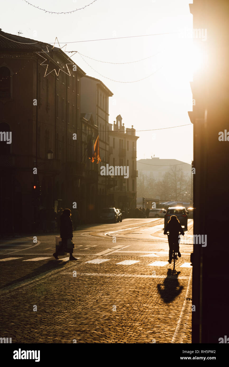 Pedestrian and bike on a street during sunset Stock Photo - Alamy