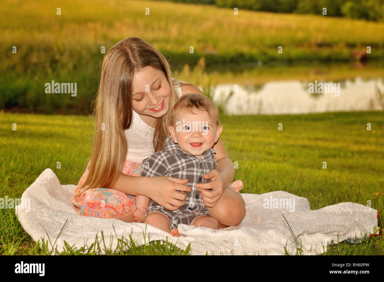girl holding baby on a blanket Stock Photo Alamy