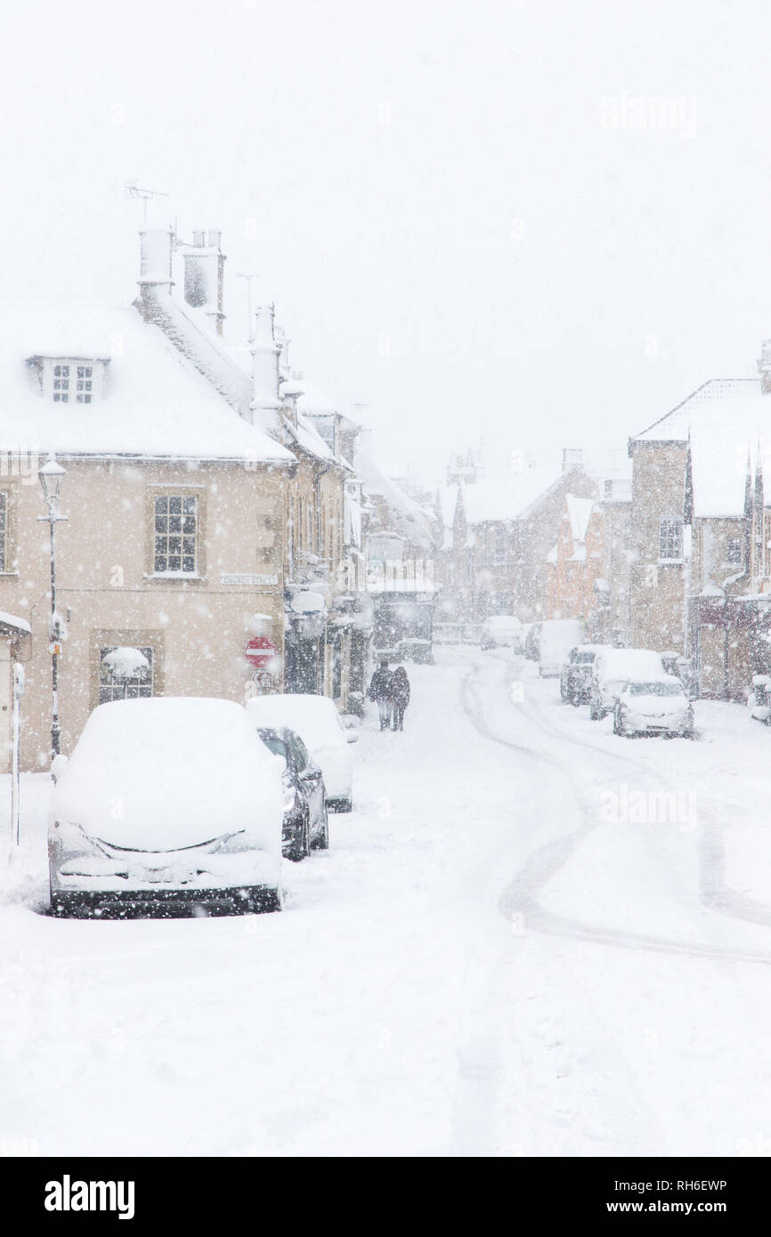 Corsham, Wiltshire, UK. 1st February, 2019. Heavy snowfall blankets the ancient town centre, home to the TV series Poldark and now a wintery scene which was forecast, though arrived late and much heavier than earlier predictions. Local residents brave the cold conditions as heavy snowfall continues to accumulate   throughout the day - with revised forecasts reporting sustained snow until 6pm this evening. The roads   are empty of cars, many schools and business remain closed whilst the wintery weather continues it's icy   grip in Wiltshire. Credit: Wayne Farrell/Alamy Live News Stock Photo