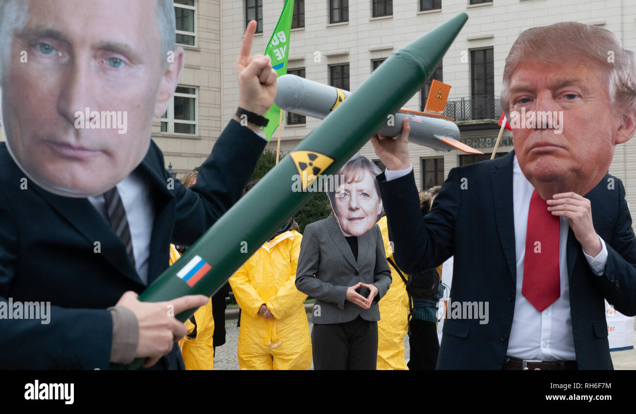 Berlin, Germany. 01st Feb, 2019. Demonstrators with a Putin and Trump mask and a Merkel mask face each other with rocket models on Pariser Platz. They are protesting with their action against the imminent end of the INF disarmament agreement between Russia and the USA. The agreement on Intermediate Range Nuclear Forces is to be dissolved by the USA. Credit: Paul Zinken/dpa/Alamy Live News Stock Photo