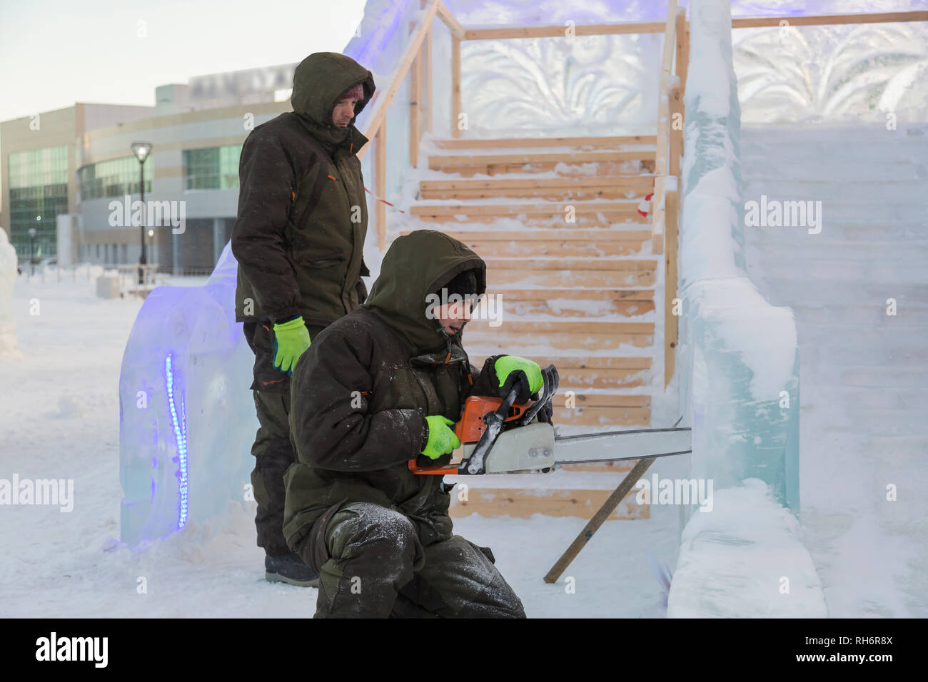 Work installer with a chainsaw in his hands undercut ice block Stock