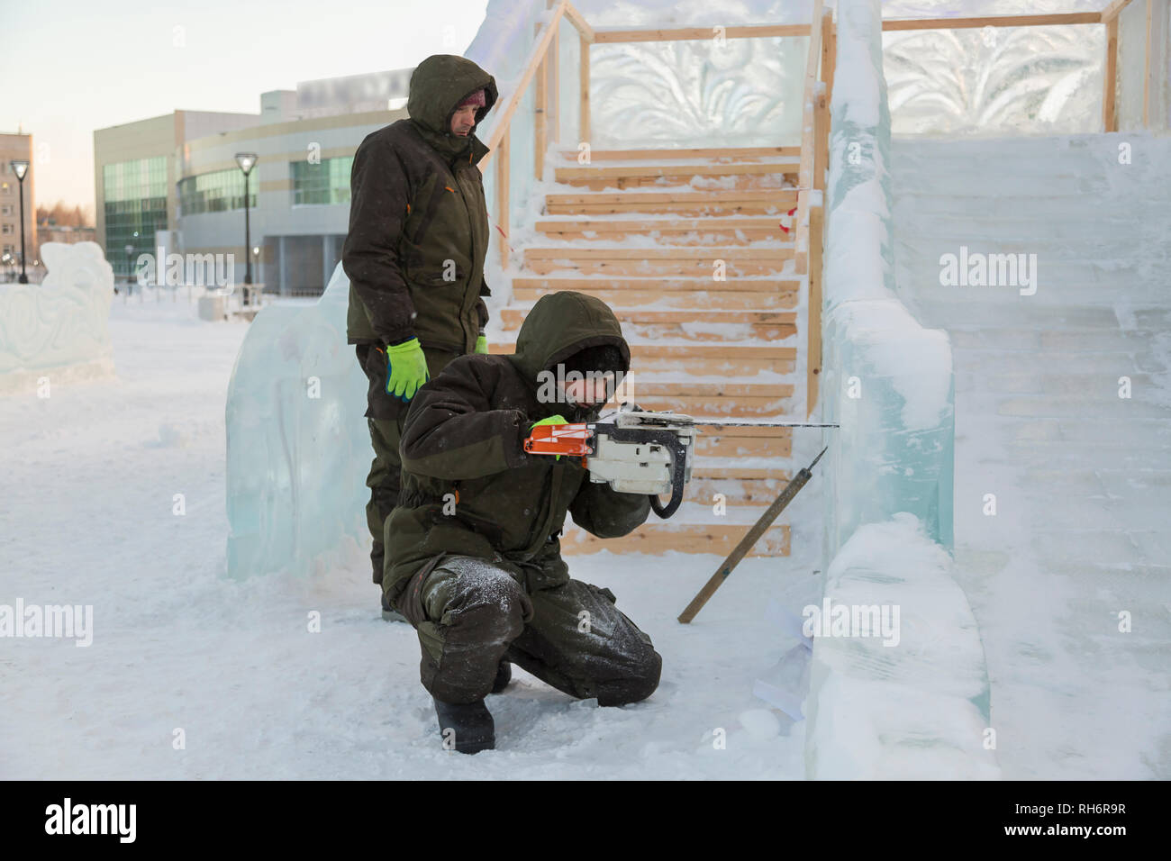 Work installer with a chainsaw in his hands undercut ice block Stock