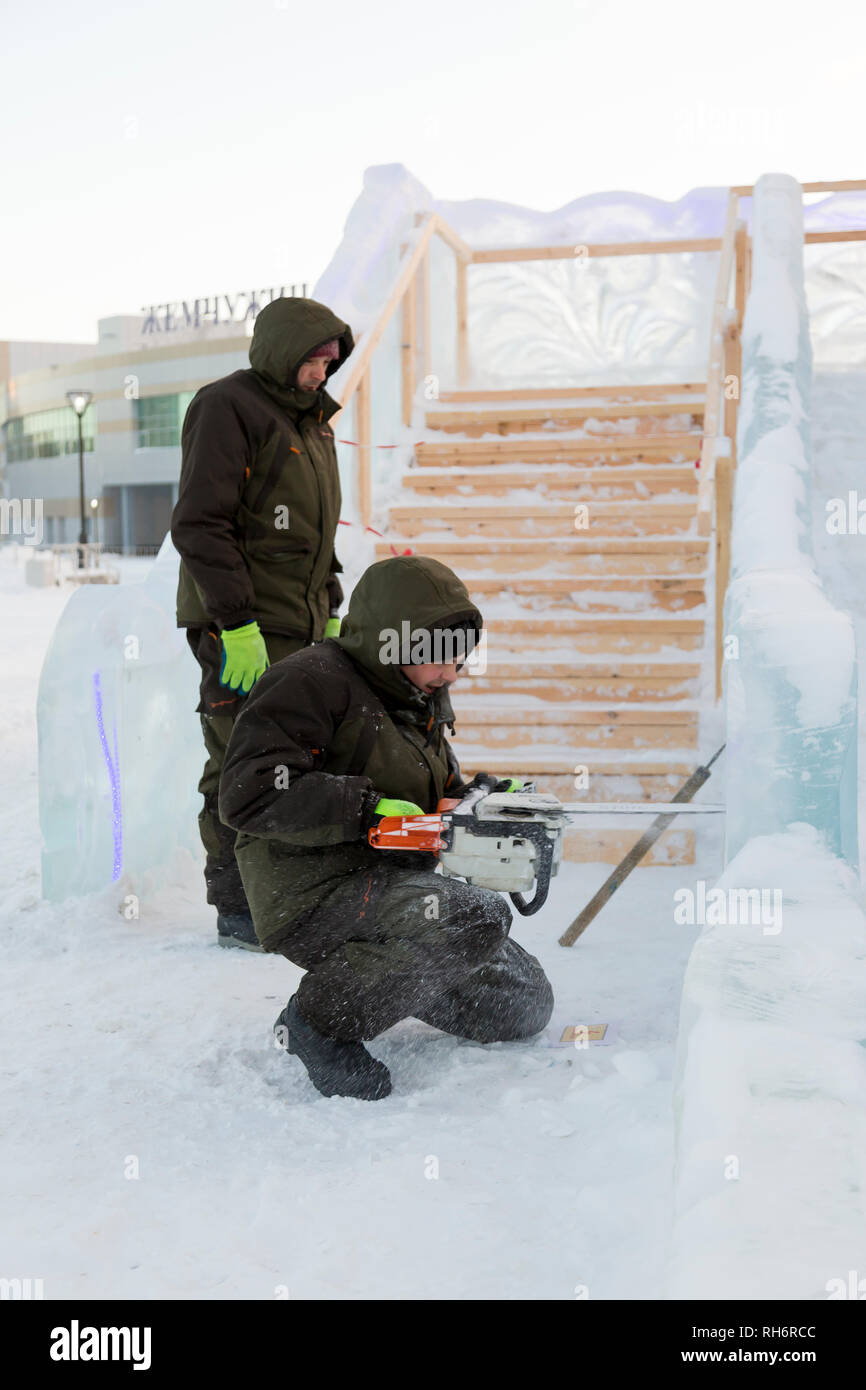 Work installer with a chainsaw in his hands undercut ice block Stock