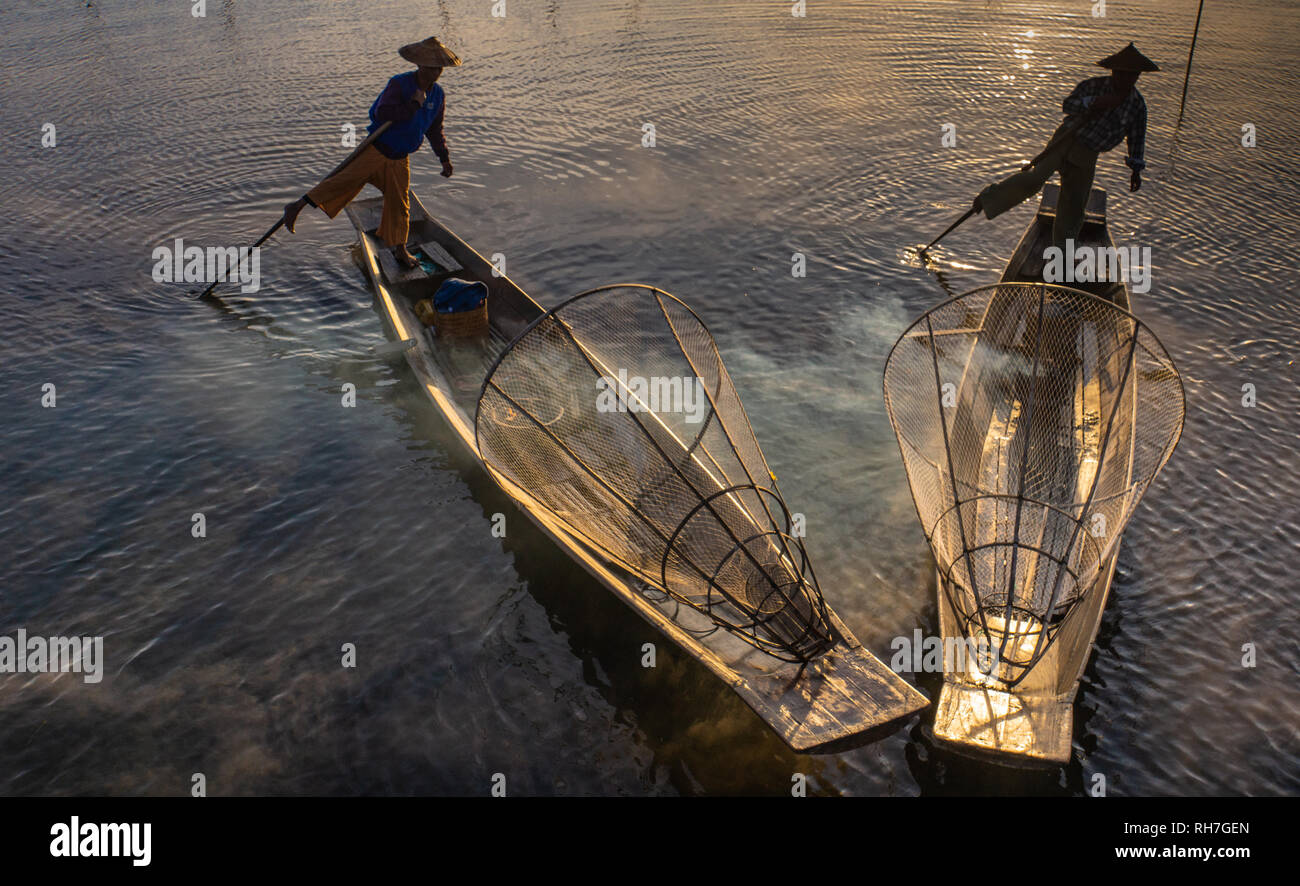 Lake Inle/ Myanmar- January 12,2019: two traditional Intha fishermen using one leg oaring method in long boat in the early morning on Lake Inle Stock Photo