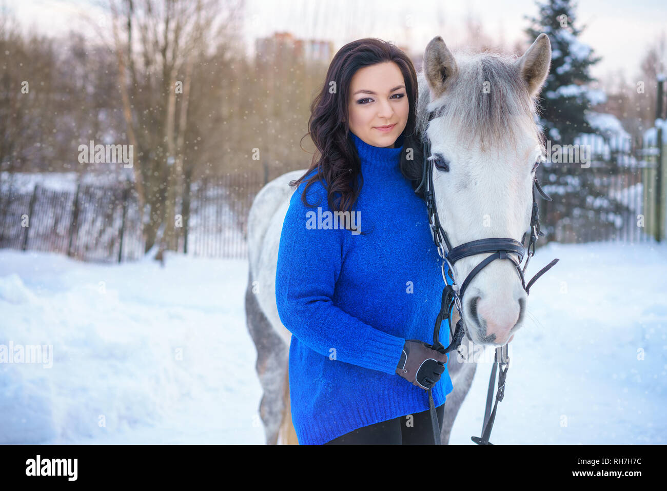 a young woman with a beautiful winter white horse Stock Photo