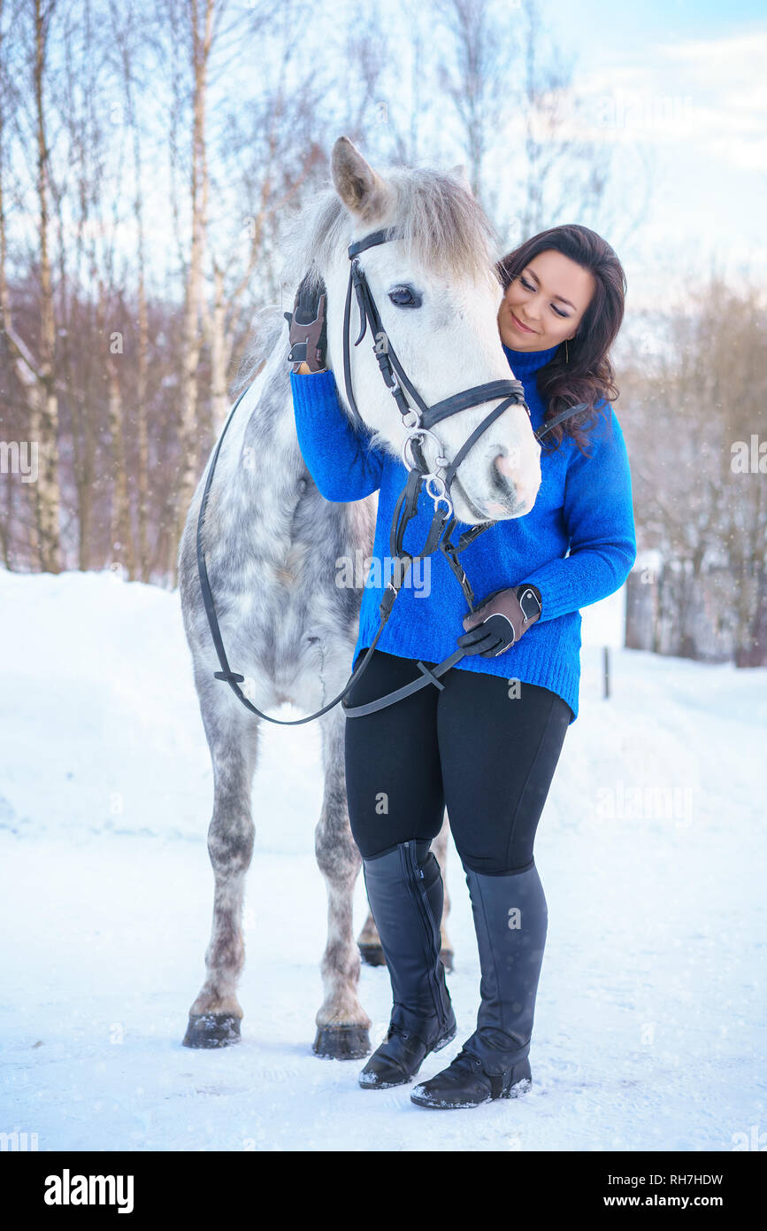 a young woman with a beautiful winter white horse Stock Photo