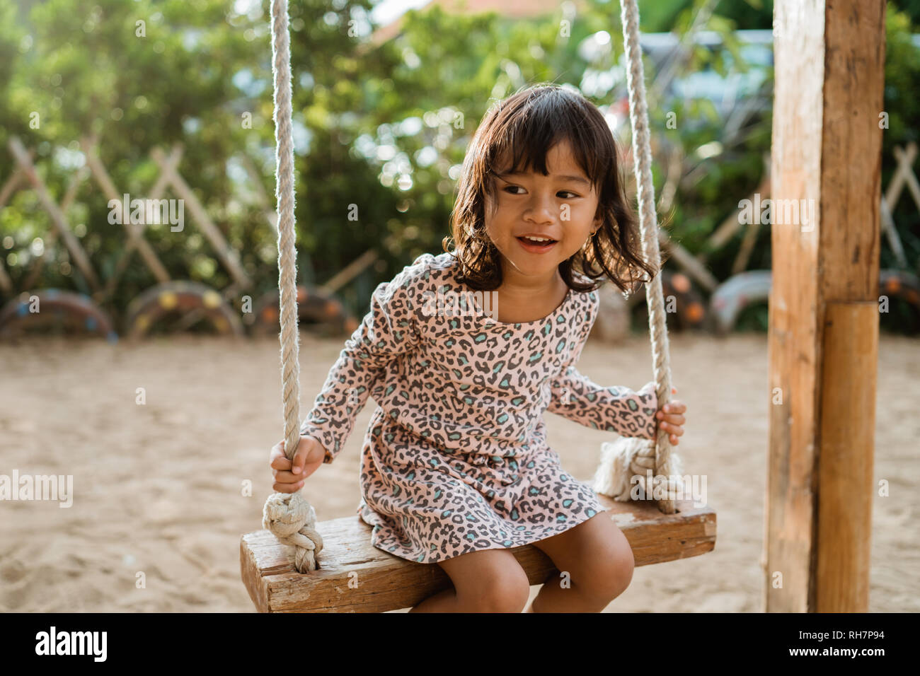 a cute asian little girl playing a swing in the playground Stock Photo ...