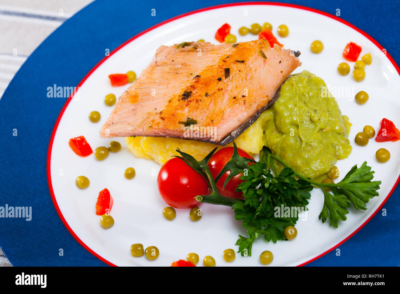 Healthy dinner, grilled trout fillet with potato puree, guacamole, peas