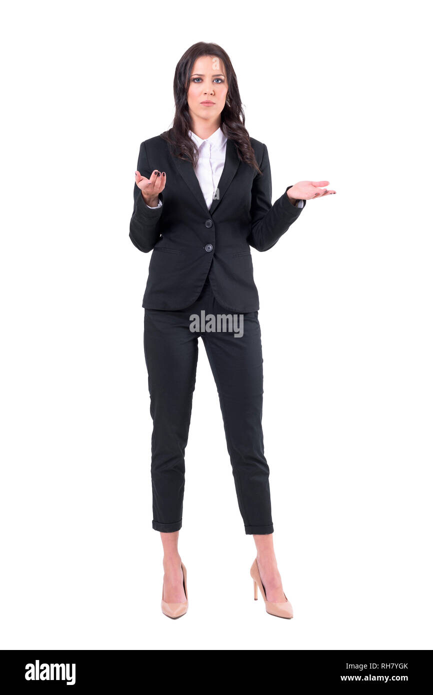 Misunderstanding concept. Uncertain business woman in black suit shrugging shoulders. Full body isolated on white background. Stock Photo