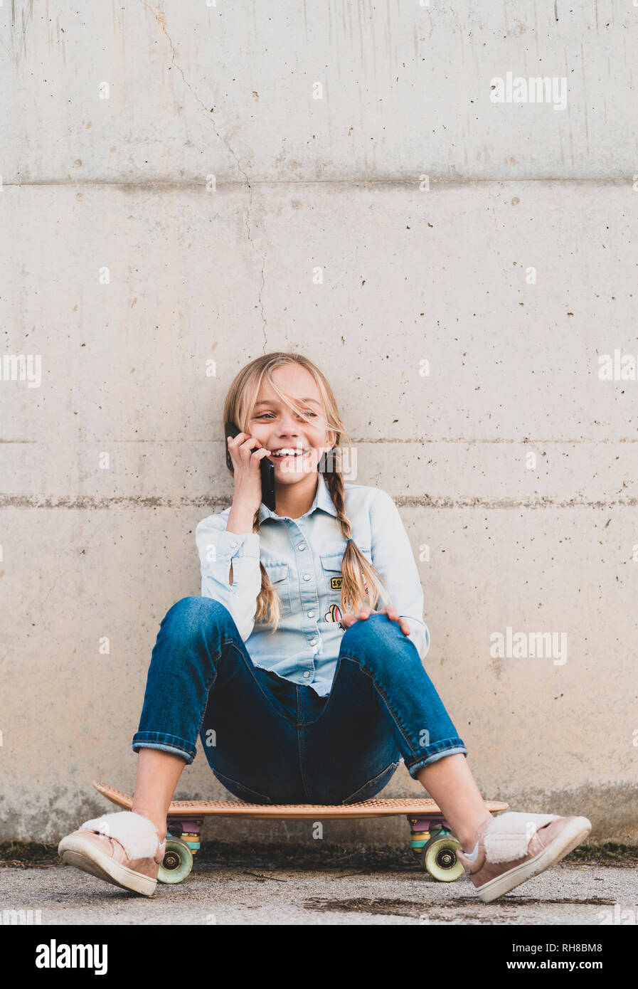 Kid using mobile phone with skate Stock Photo