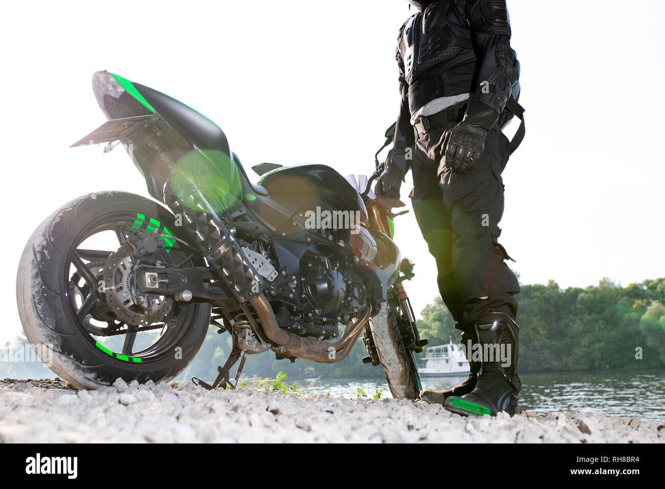 Biker man and motorcycle with river background, Rider moto trip on the ...