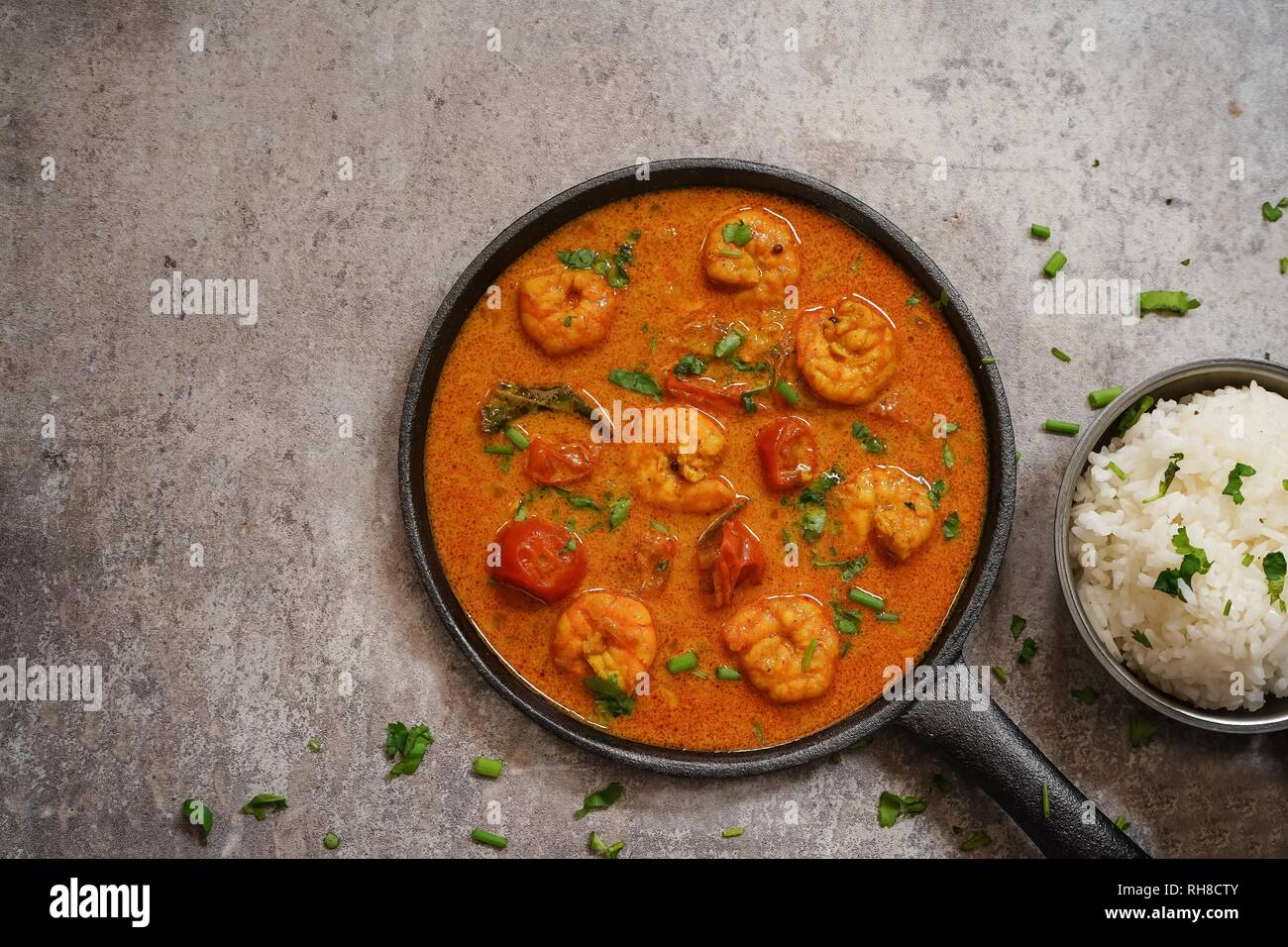 Shrimp in curry coconut sauce with rice in a bowl Curried prawns