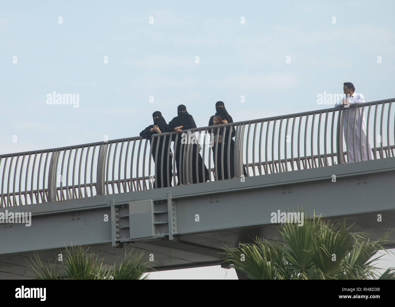 Saudi women in niqabs looking over a bridge, Mecca province, Jeddah, Saudi Arabia Stock Photo