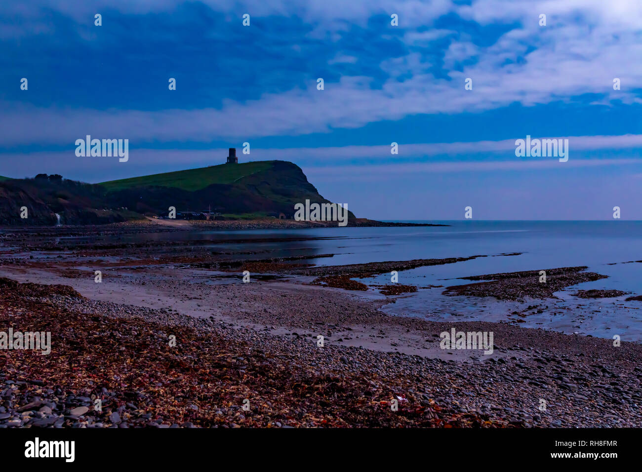 Long exposure night time photograph taken on Kimmeridge bay beach with cliffs and Clavell tower in background. Dorset, England Stock Photo