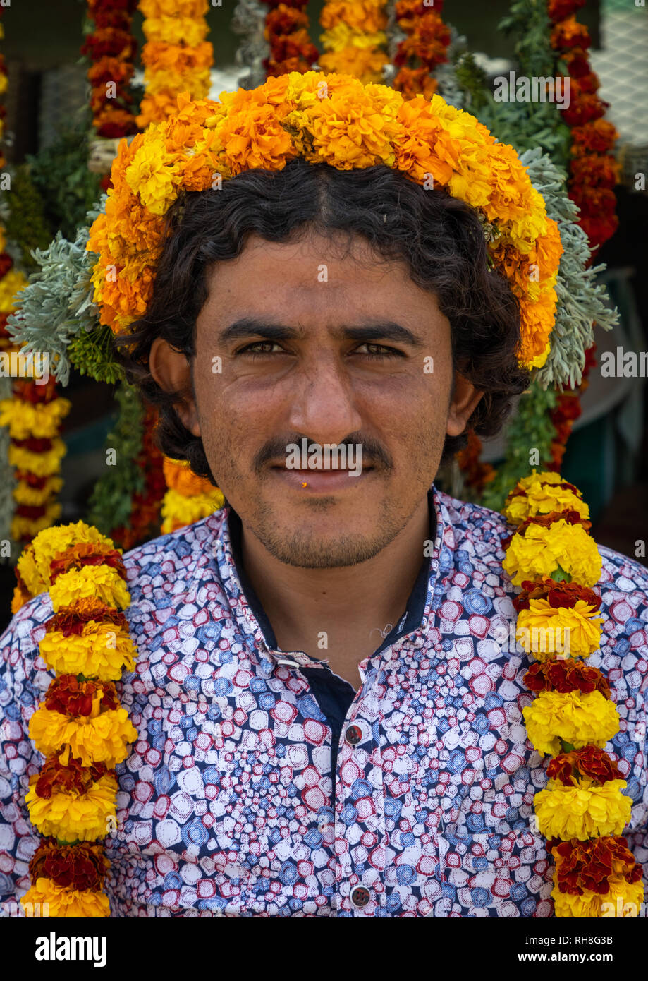 A flower vendor with floral garlands and crowns on a market, Jizan