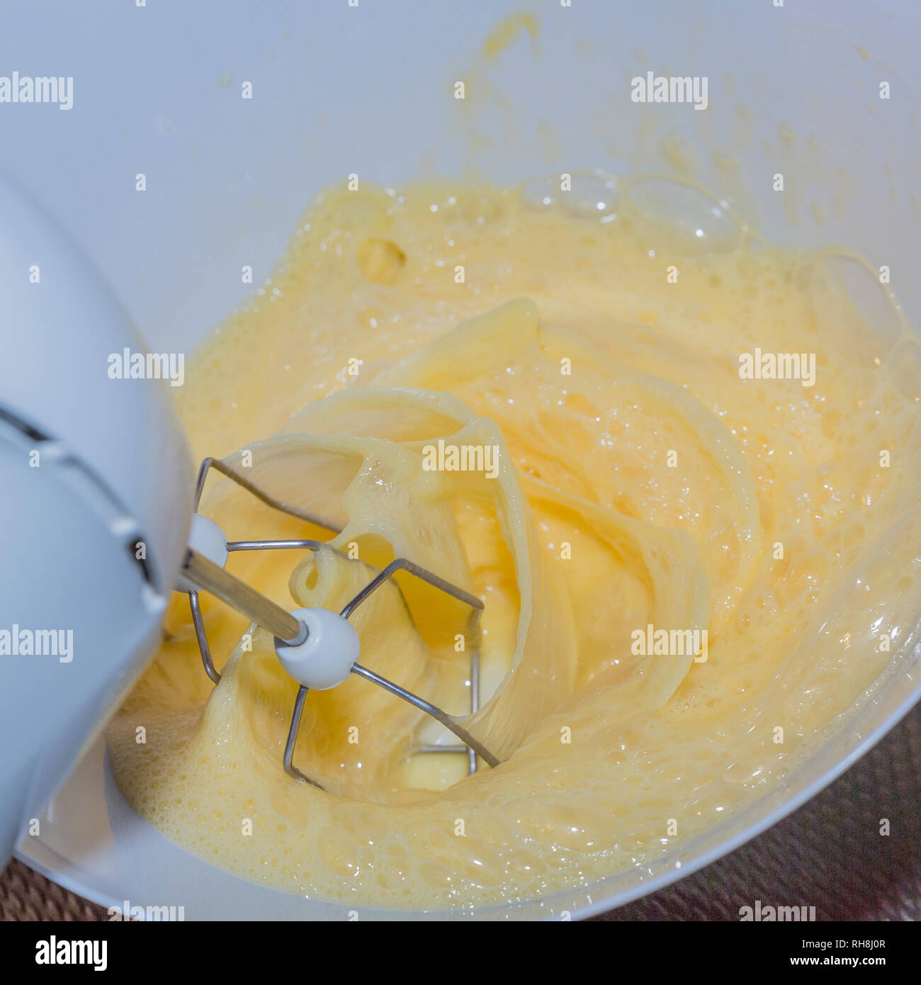 Electric blender beating some eggs in a bowl for making a cake Stock
