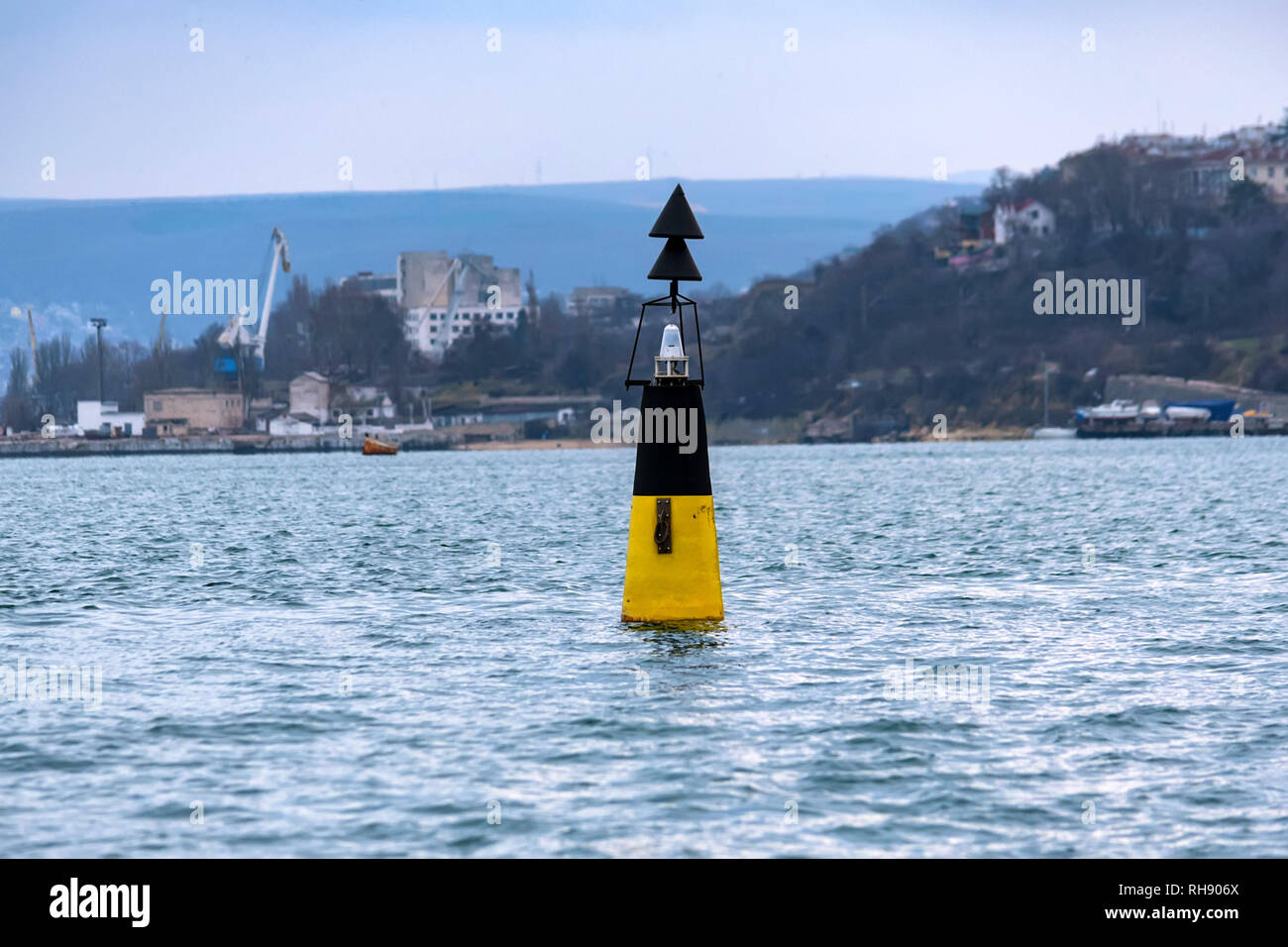 Sea buoy in the black sea with view of industrial dock in background