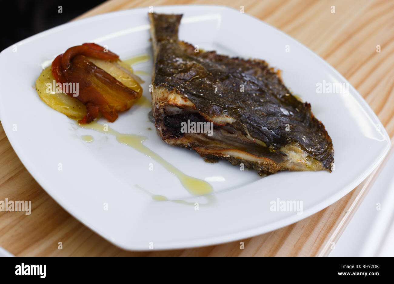 Closeup of gourmet restaurant dish of fried flounder with caramelized vegetables Stock Photo