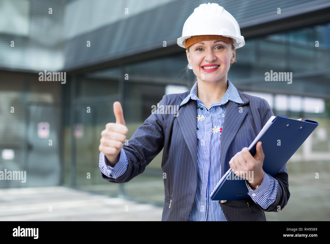 Employee woman in suit standing in helmet with paper documents Stock ...