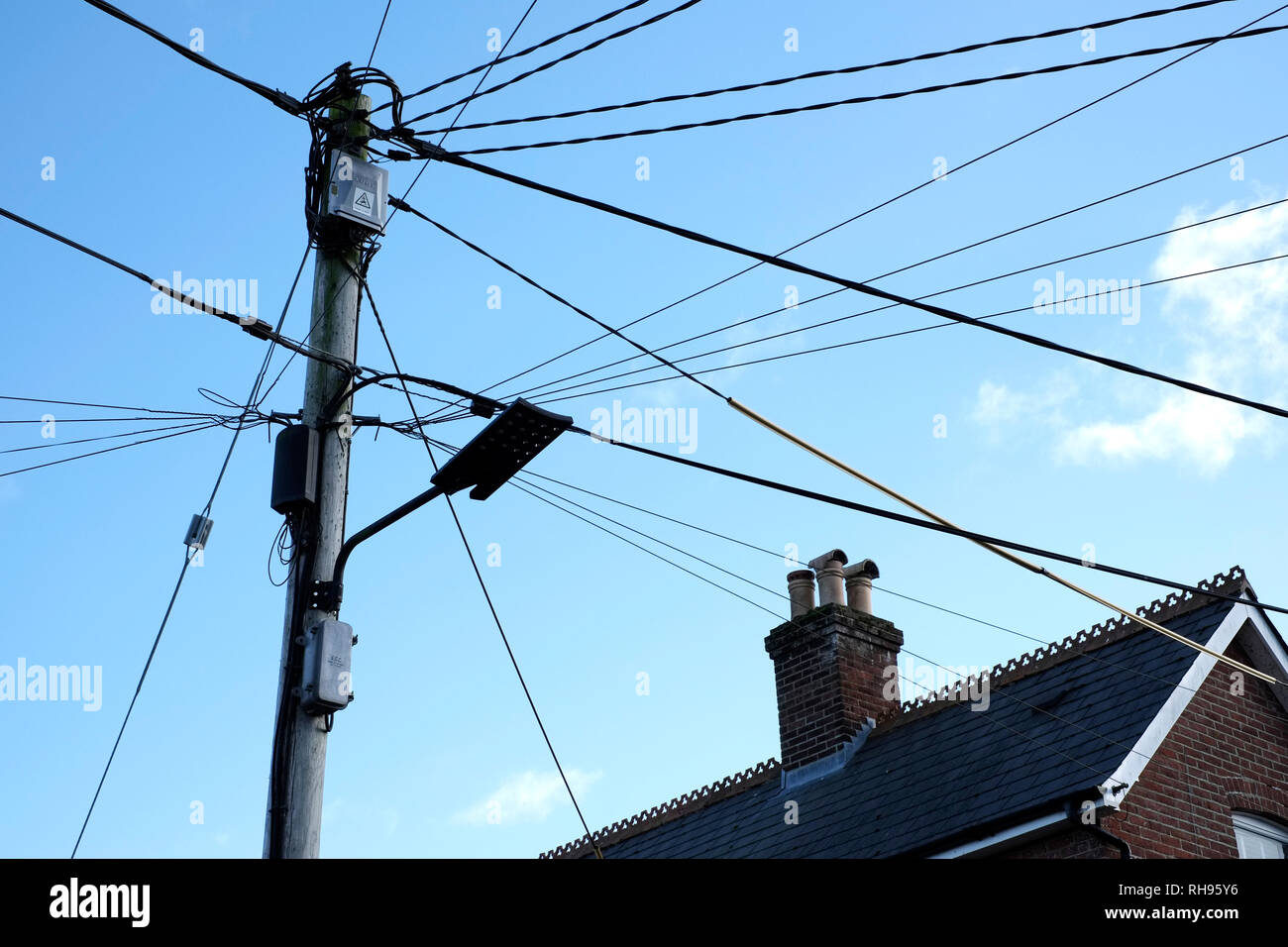 A mass of overhead telephone and electricity wires on a utility pole