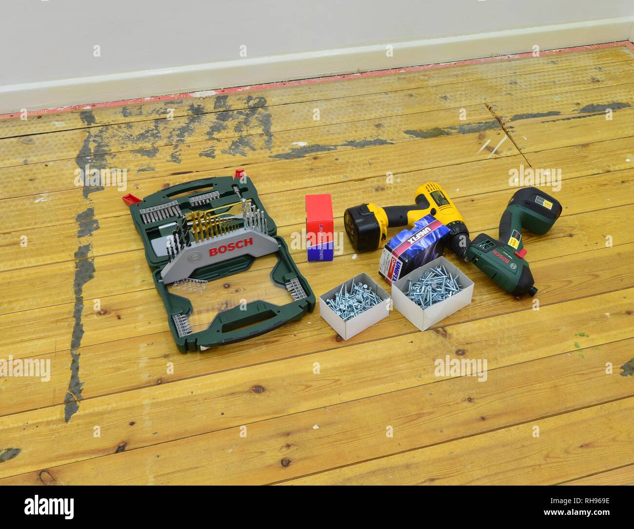 A selection of work tools and fasteners to repair loose floorboards