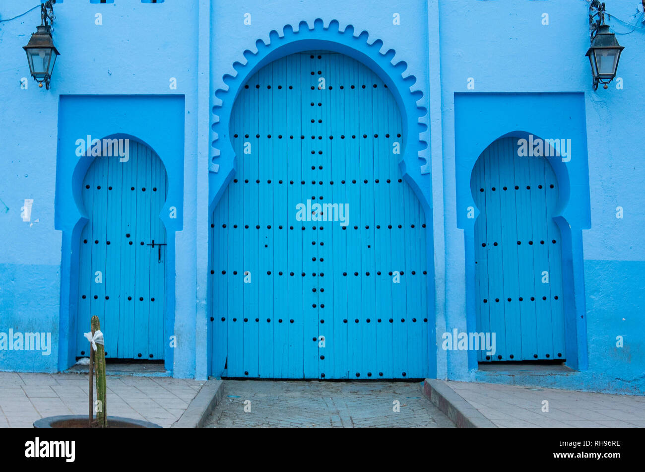 Typical, old, blue intricately carved, studded, Moroccan riad door and ...