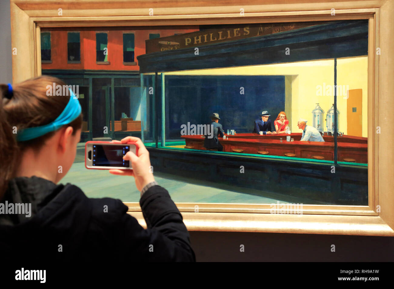 A visitor taking photos of Edward Hopper's painting Nighthawks (1942) in Art Institute of Chicago.Chicago.Illinois.USA Stock Photo