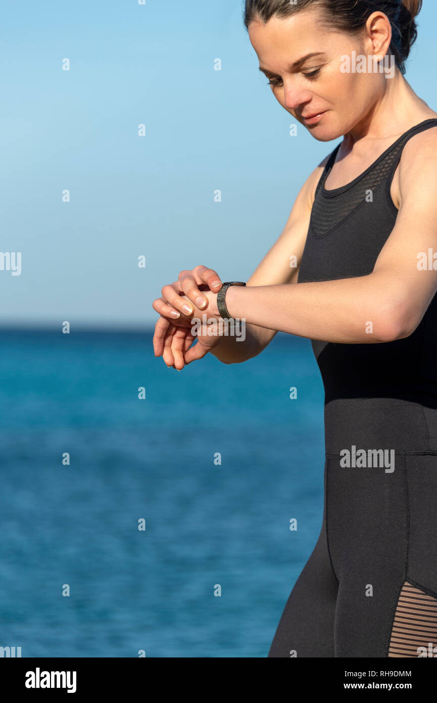 woman runner checking her smart watch Stock Photo