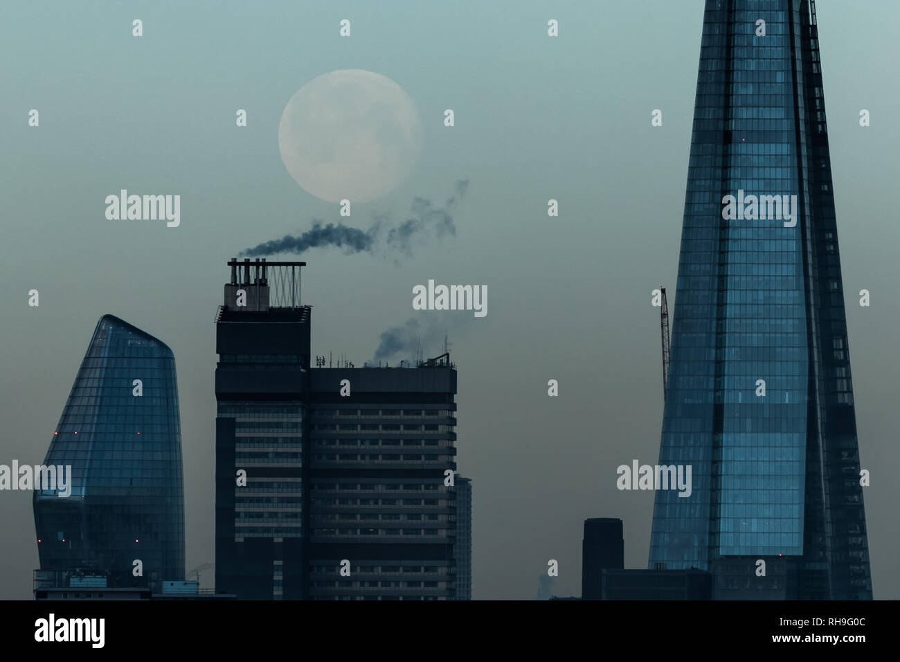 UK Weather: The morning moon sets near the Shard skyscraper building Stock Photo