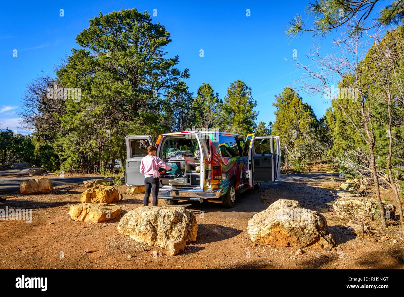 Young woman cooking at the gas stove of a camping van, campervan, camping, RV, Mather Campground, Grand Canyon National Park Stock Photo