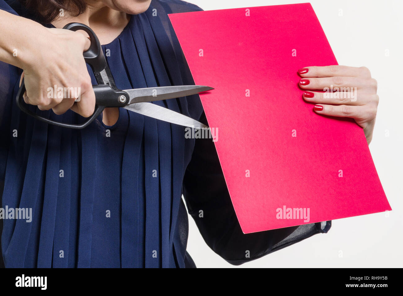 Someone Using Scissors A woman holds scissors and a sheet of paper, cuts paper. White ...