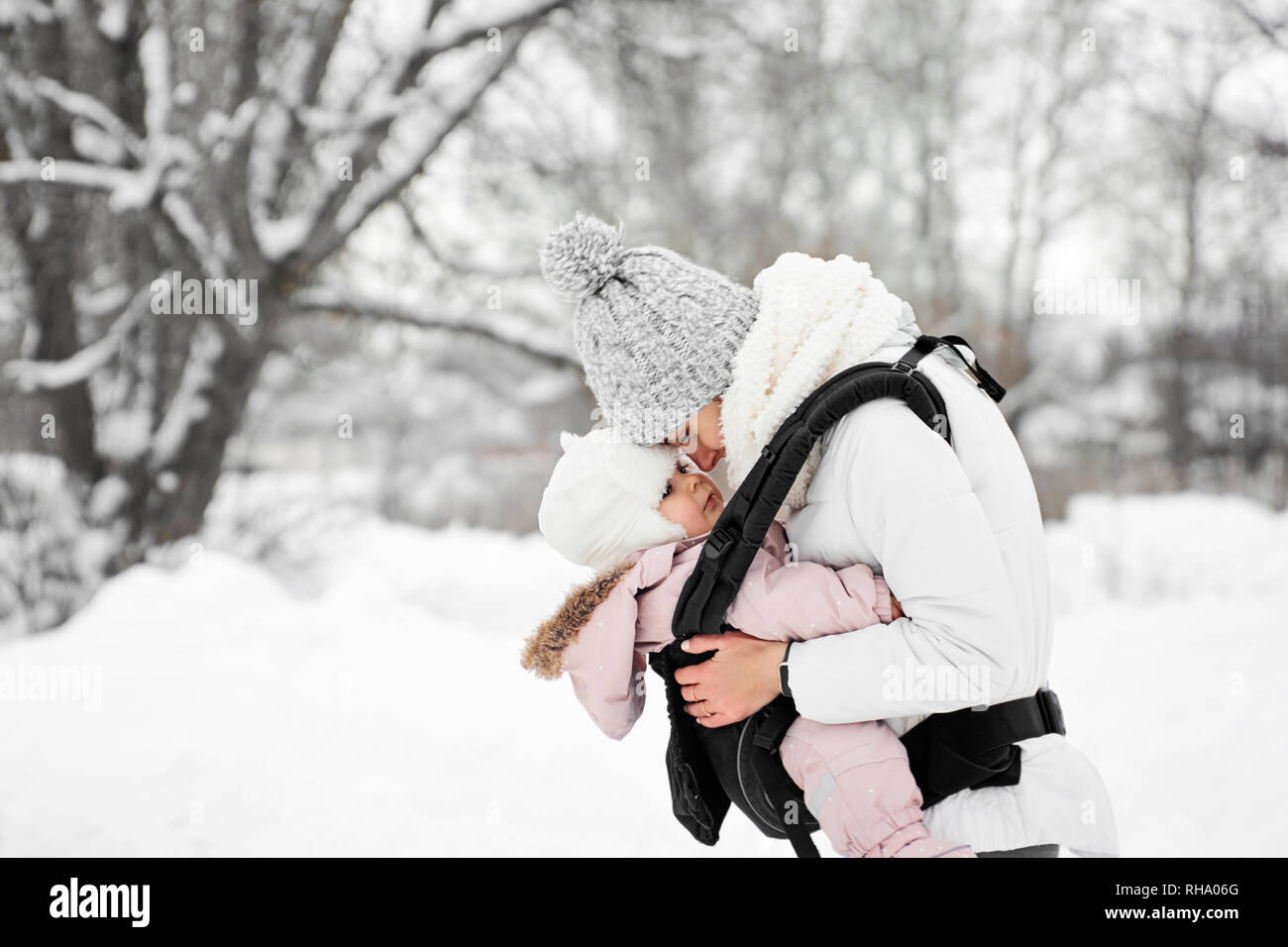 Little baby girl and her mother walking outside in winter Mother is