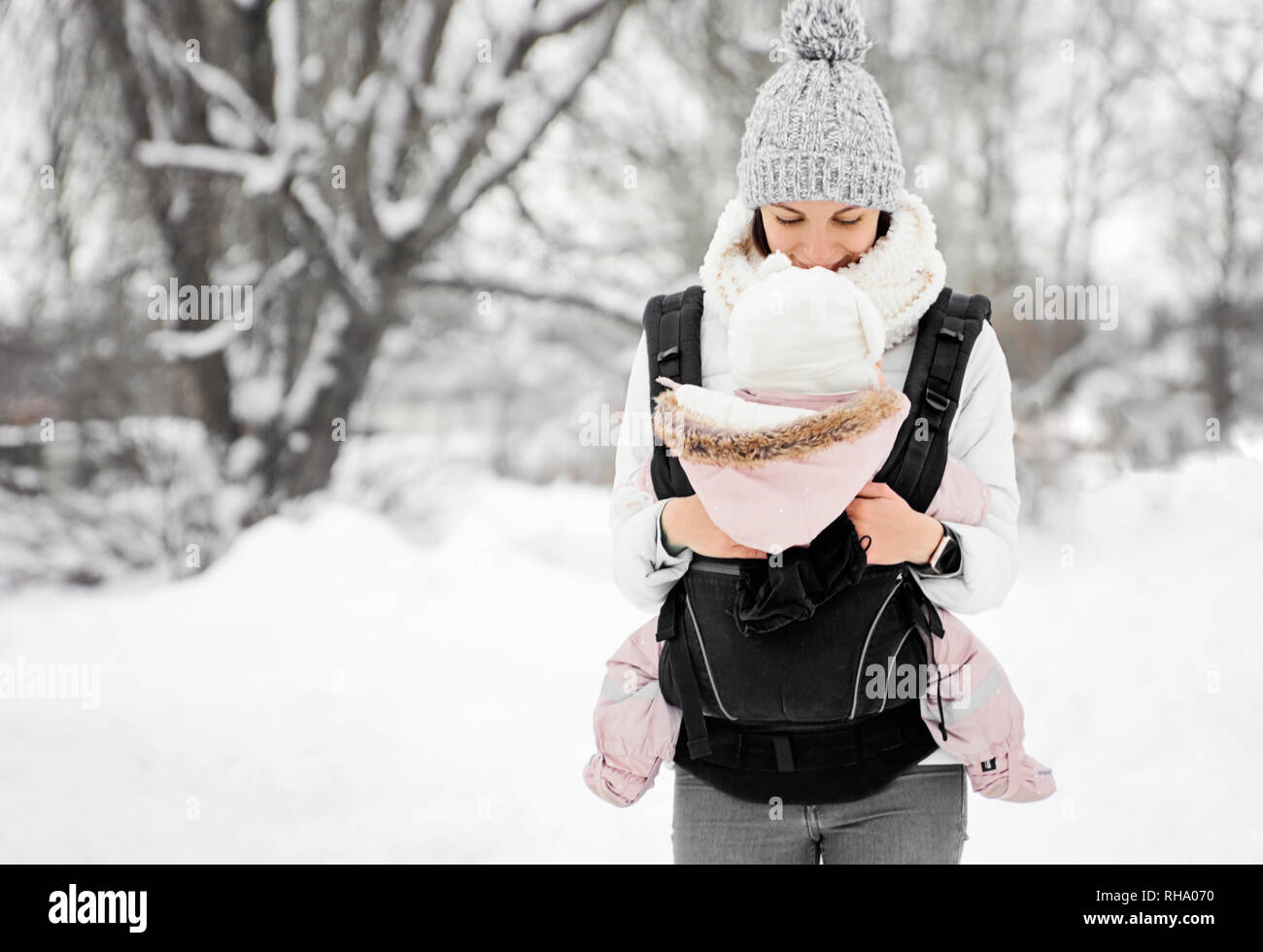 Little baby girl and her mother walking outside in winter Mother is