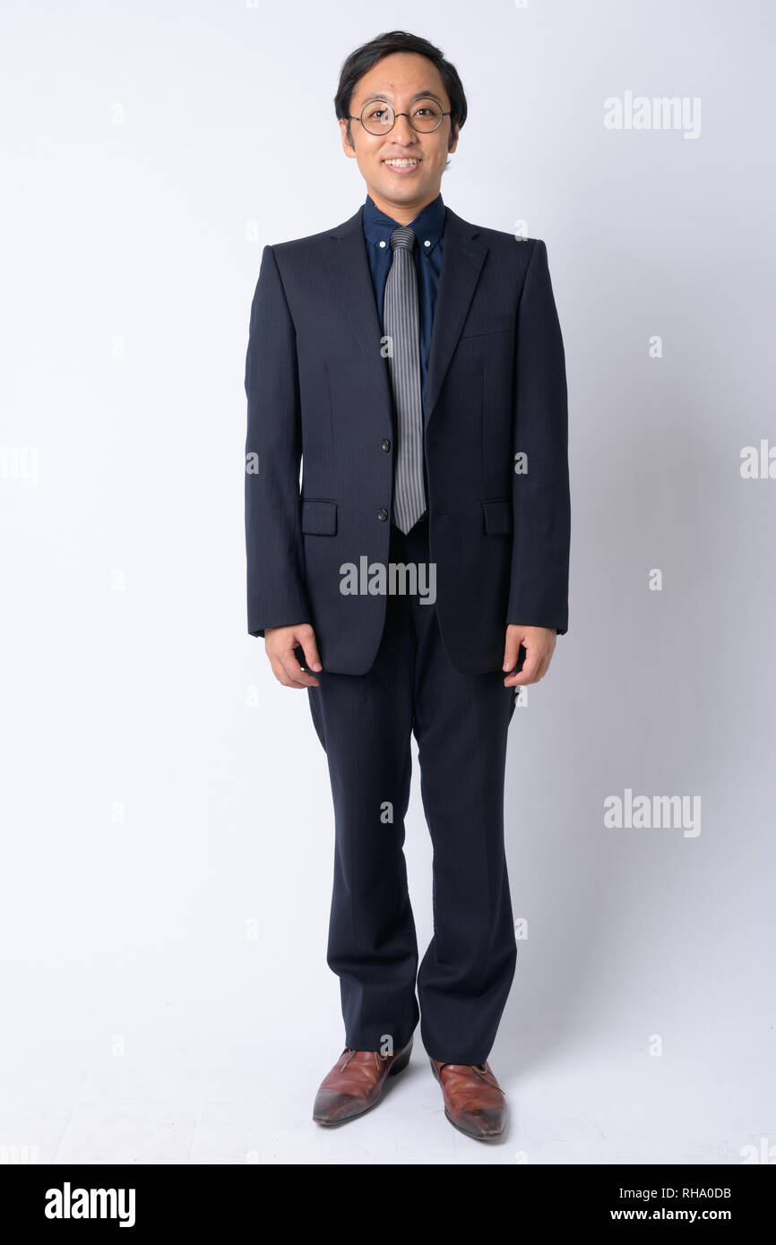 Full body shot of happy Japanese businessman in suit smiling Stock ...
