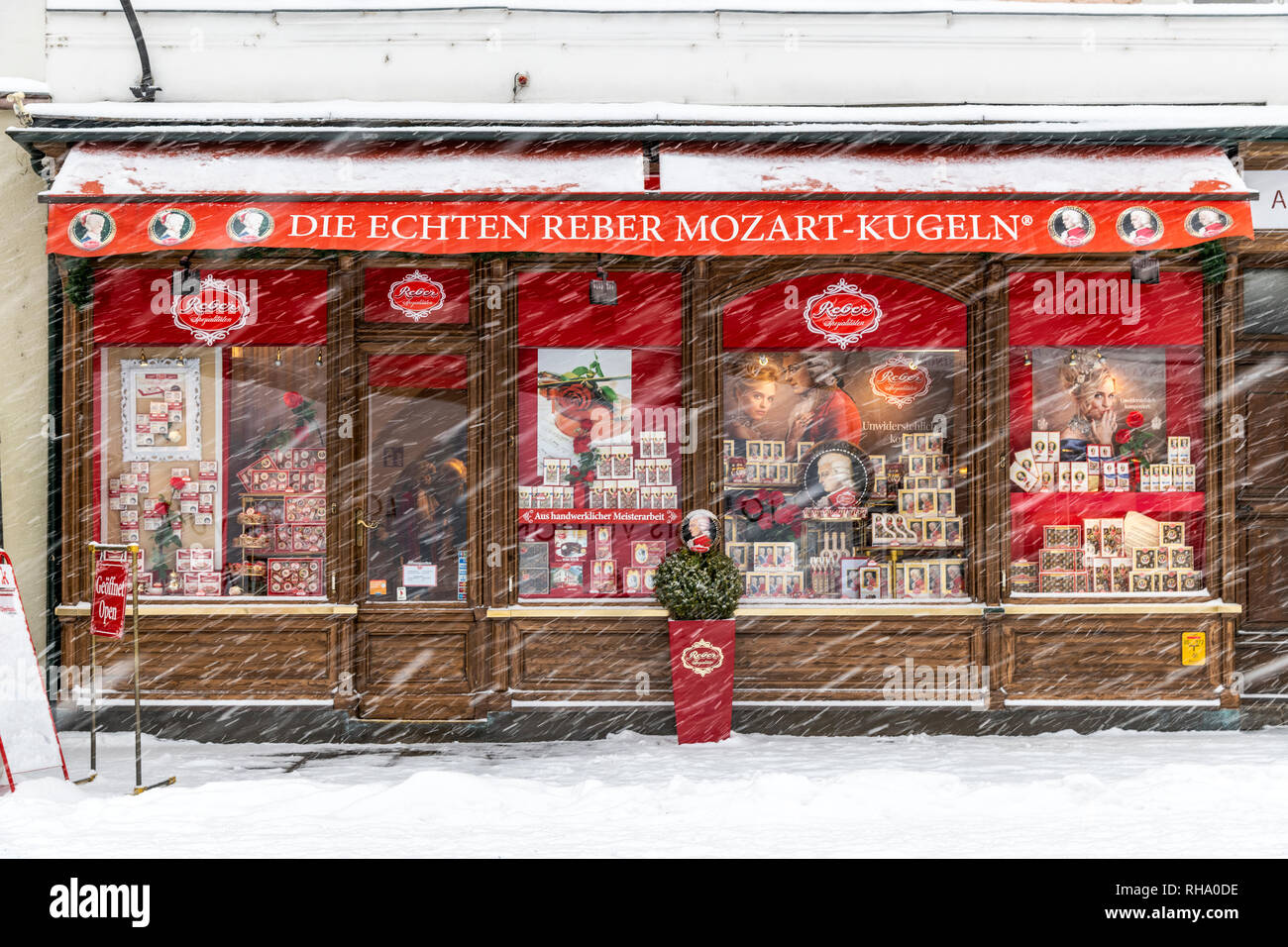 The historical and famous Echten Reber Mozart Kugeln chocolate shop in a snow day, Alter Markt Square, Salzburg, Austria Stock Photo