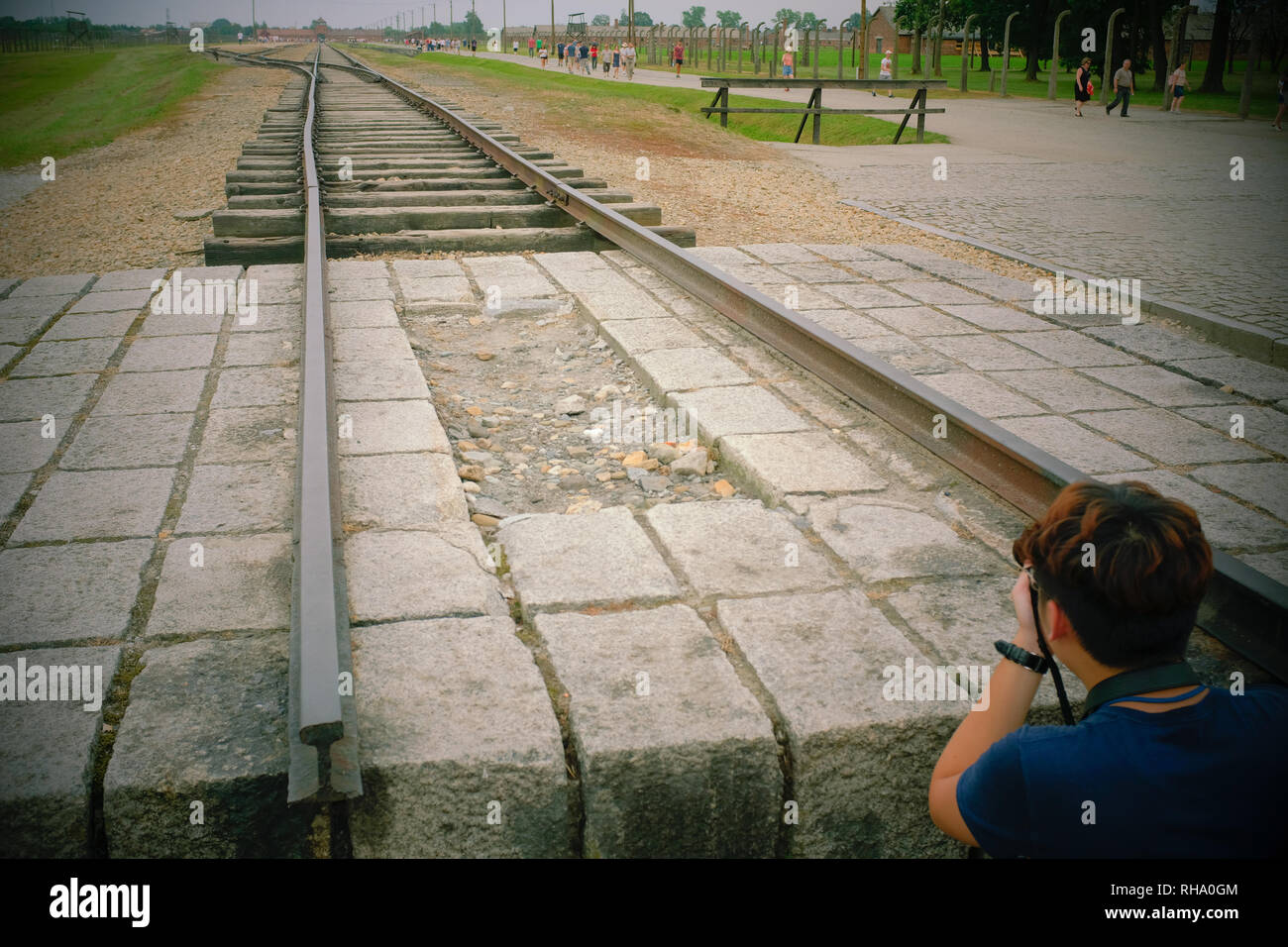 Boy taking photograph of rail track at Birkenau - Auschwitz Stock Photo
