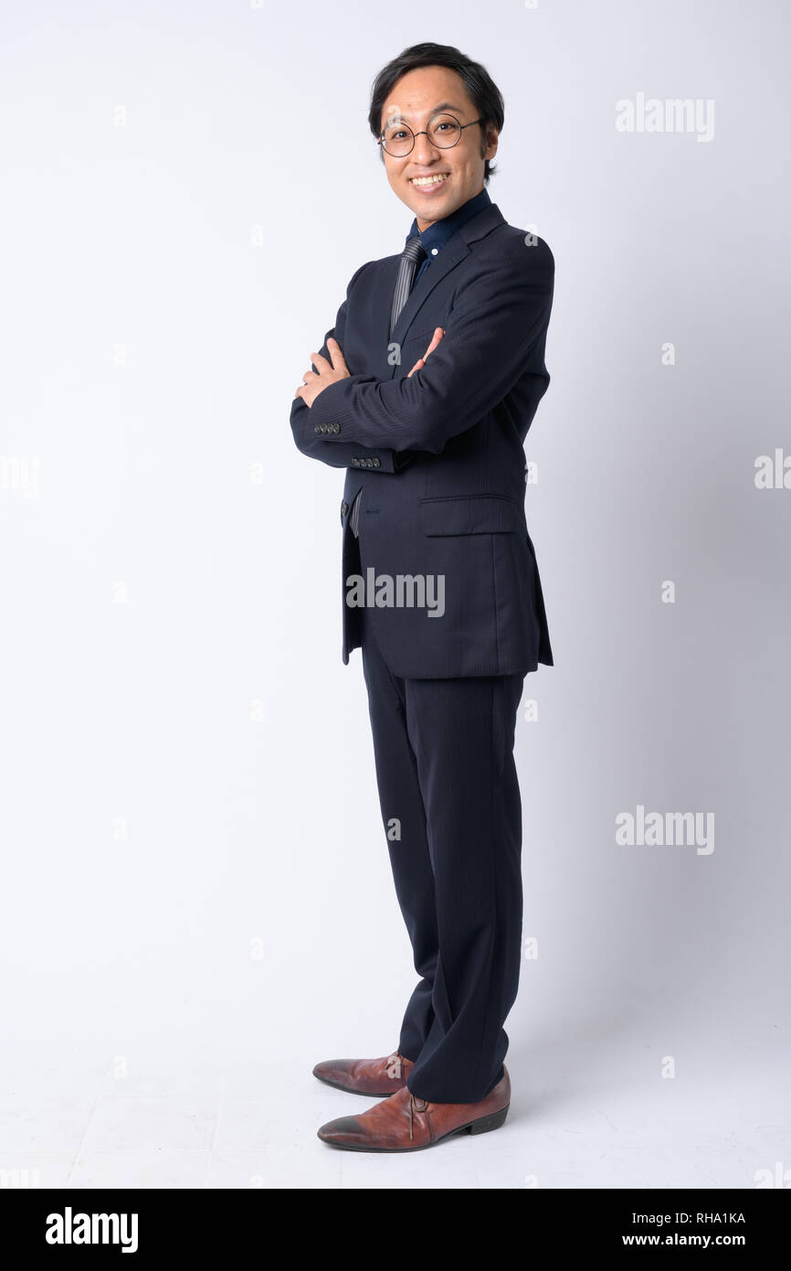 Full body shot profile view of happy Japanese businessman in suit with ...