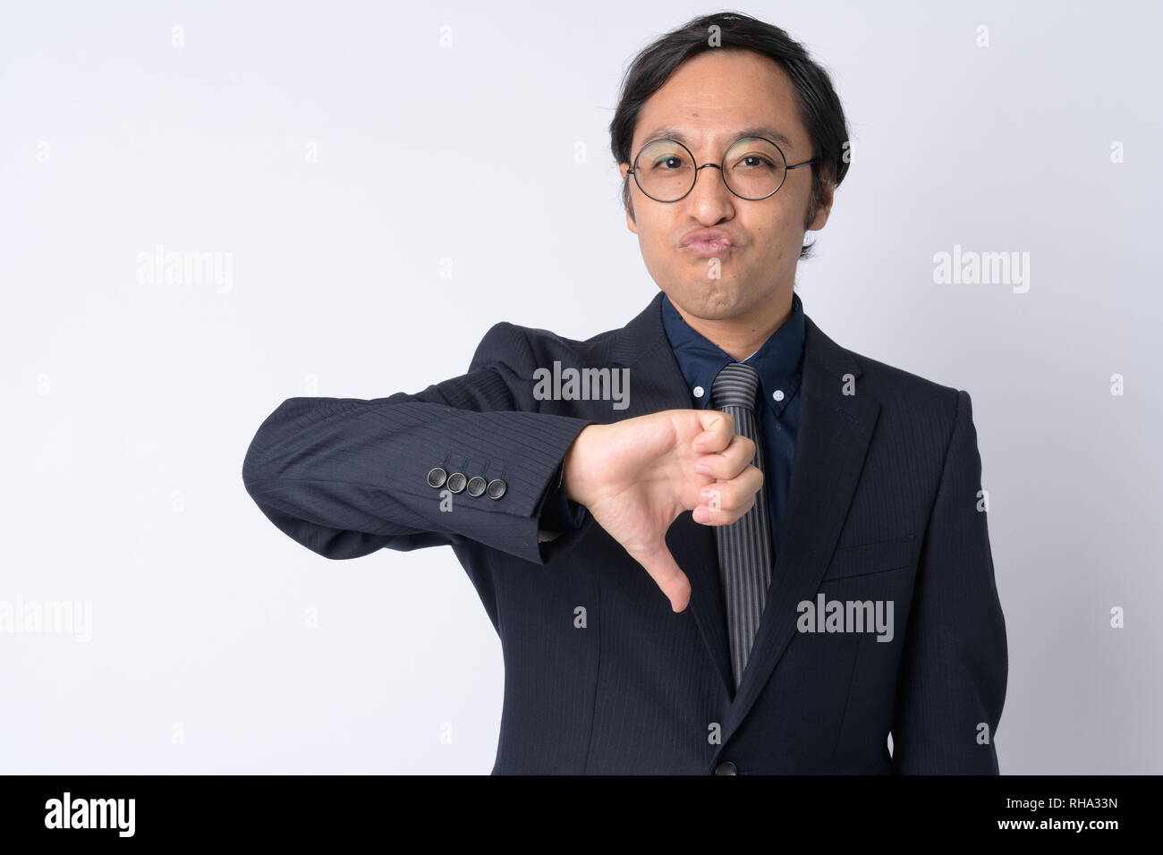 Portrait of Japanese businessman in suit giving thumbs down Stock Photo ...
