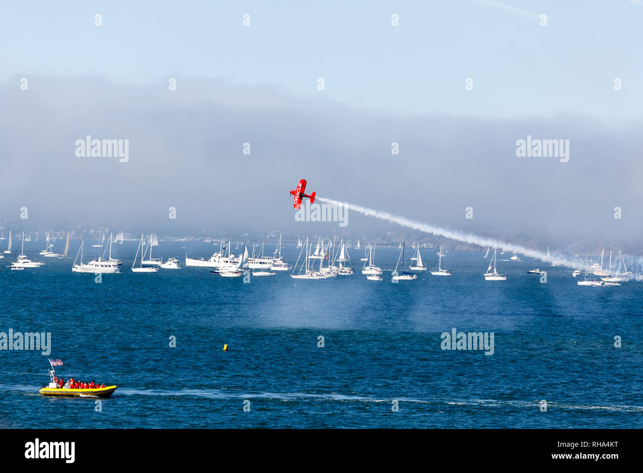 Red baron flies low over boat during blue angels air show over San Francisco Bay during fleet week Stock Photo