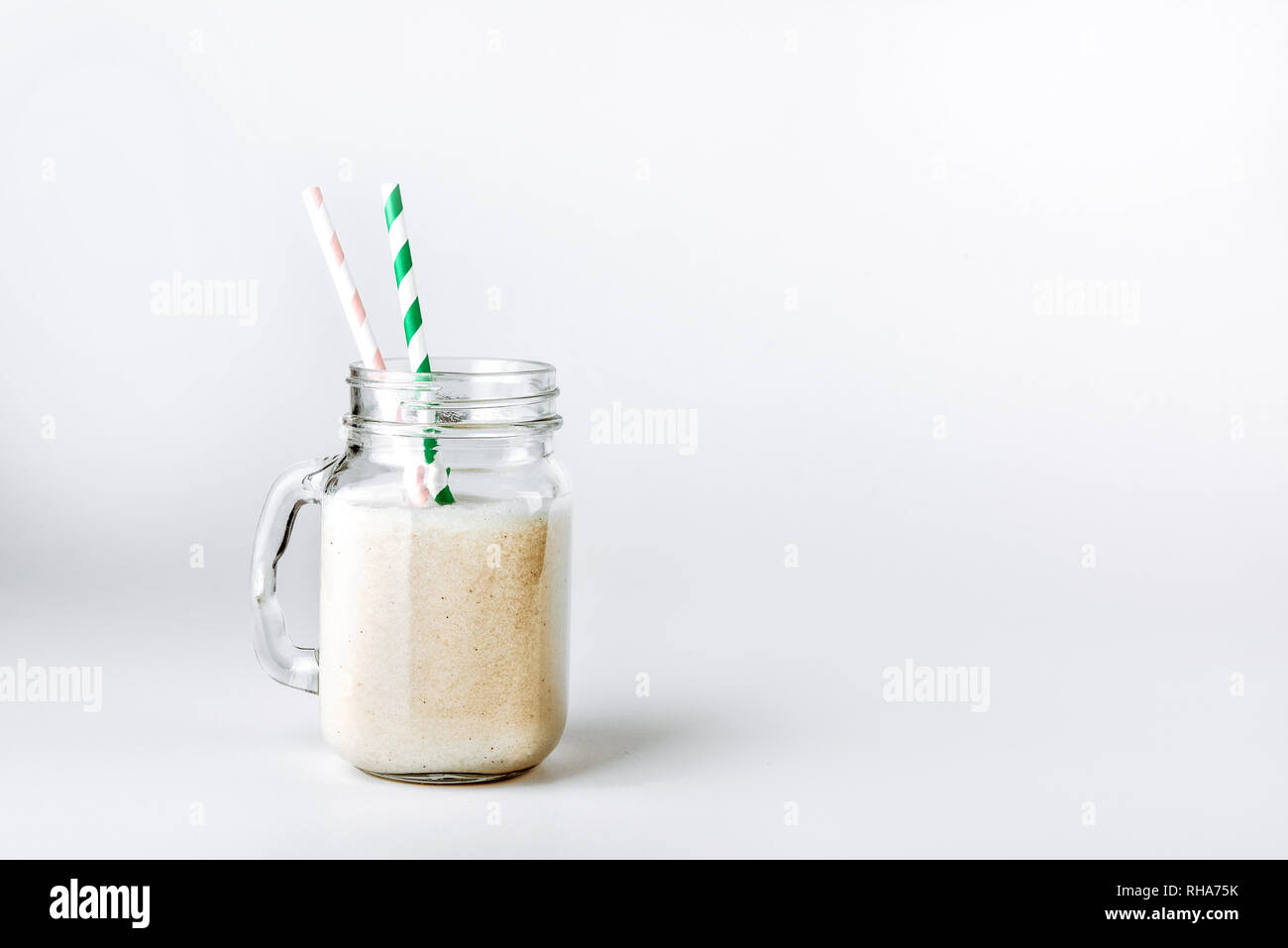 Protein cocktail with milk, vanilla in a glass jar with straws. Sports nutrition Stock Photo