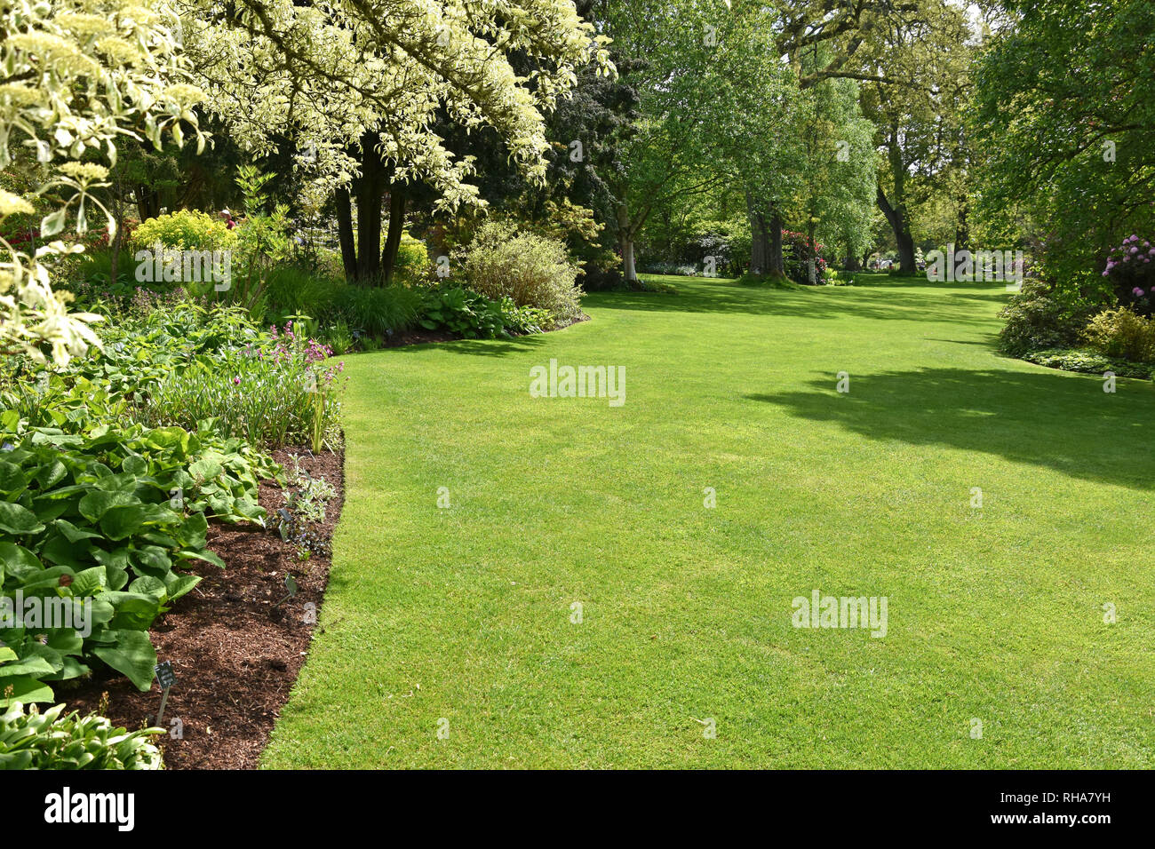 A perfect English country garden with manicured lawn surrounded by