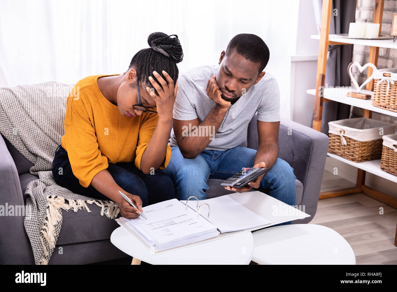 Sad African Couple Sitting On Sofa Examining Bill Stock Photo - Alamy