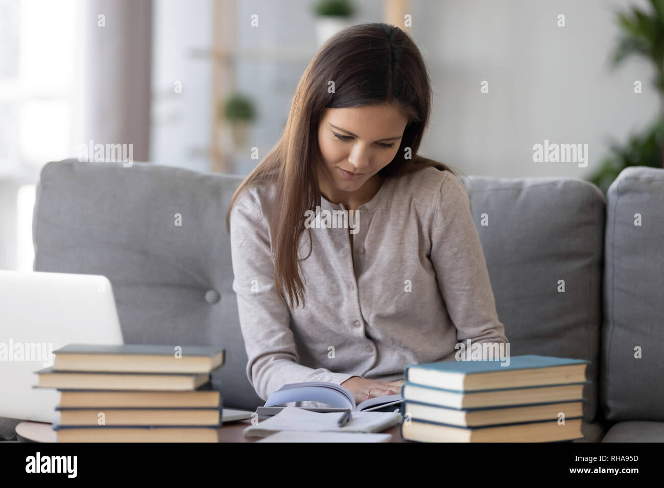 Smart student preparing for test exam reading textbook at home Stock Photo