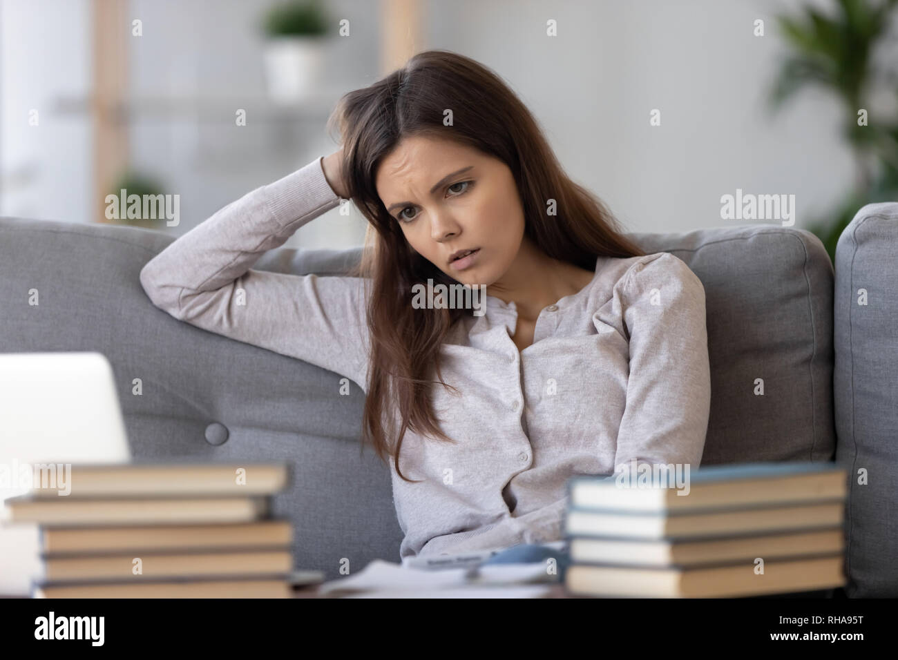 Tired bored teen looking at books stressed by exam preparation Stock Photo