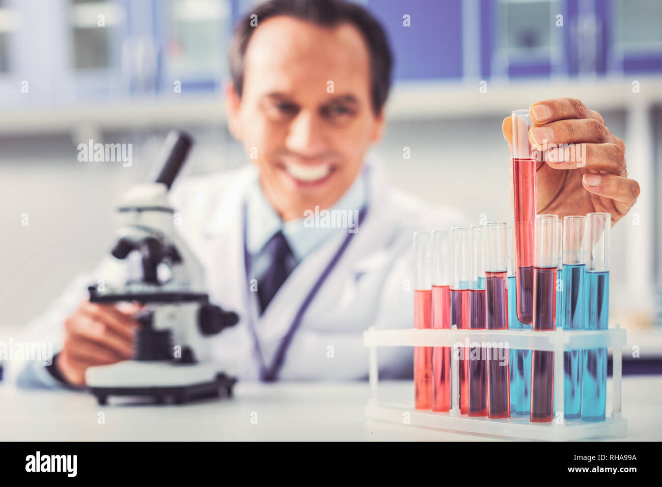 Glass tubes with different chemical substances standing near microscope