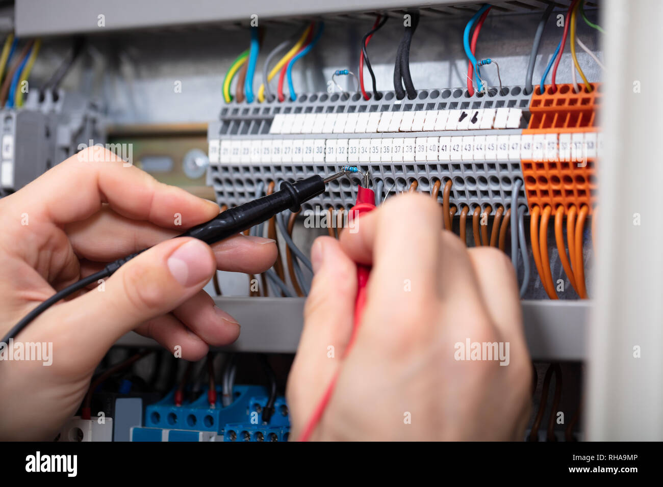 Close-up Of A Male Electrician Examining Fuse Box With Multimeter Stock Photo
