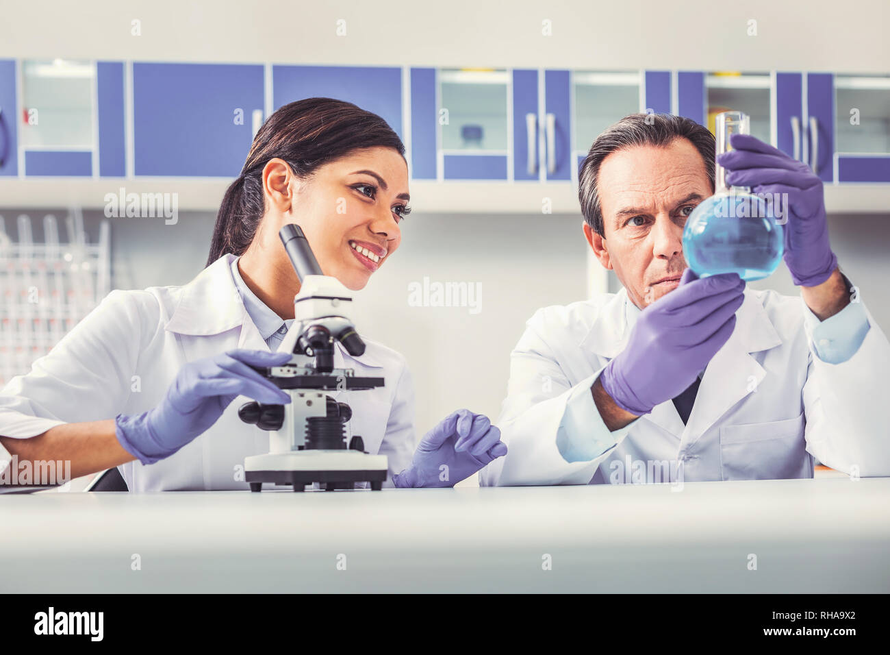 Professional biologist showing glass tube to his assistant Stock Photo