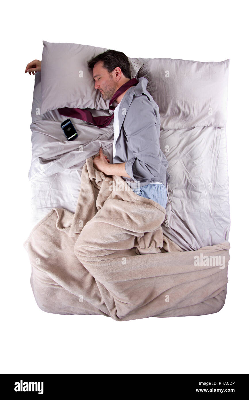 businessman sleeping in his work clothes with cellphone alarm clock Stock Photo