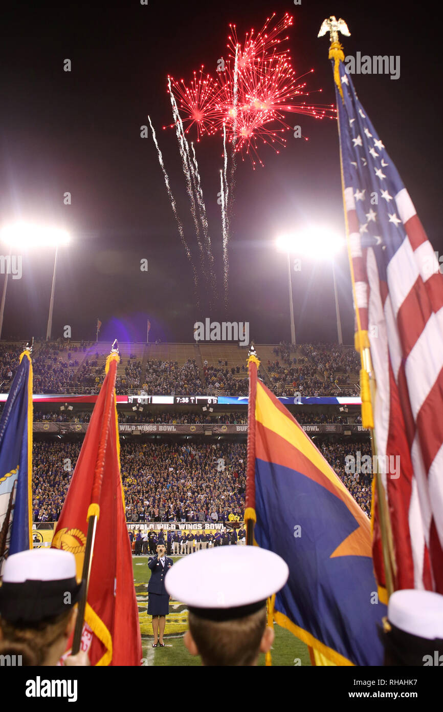 The color guard stands at attention with flags raised as the National