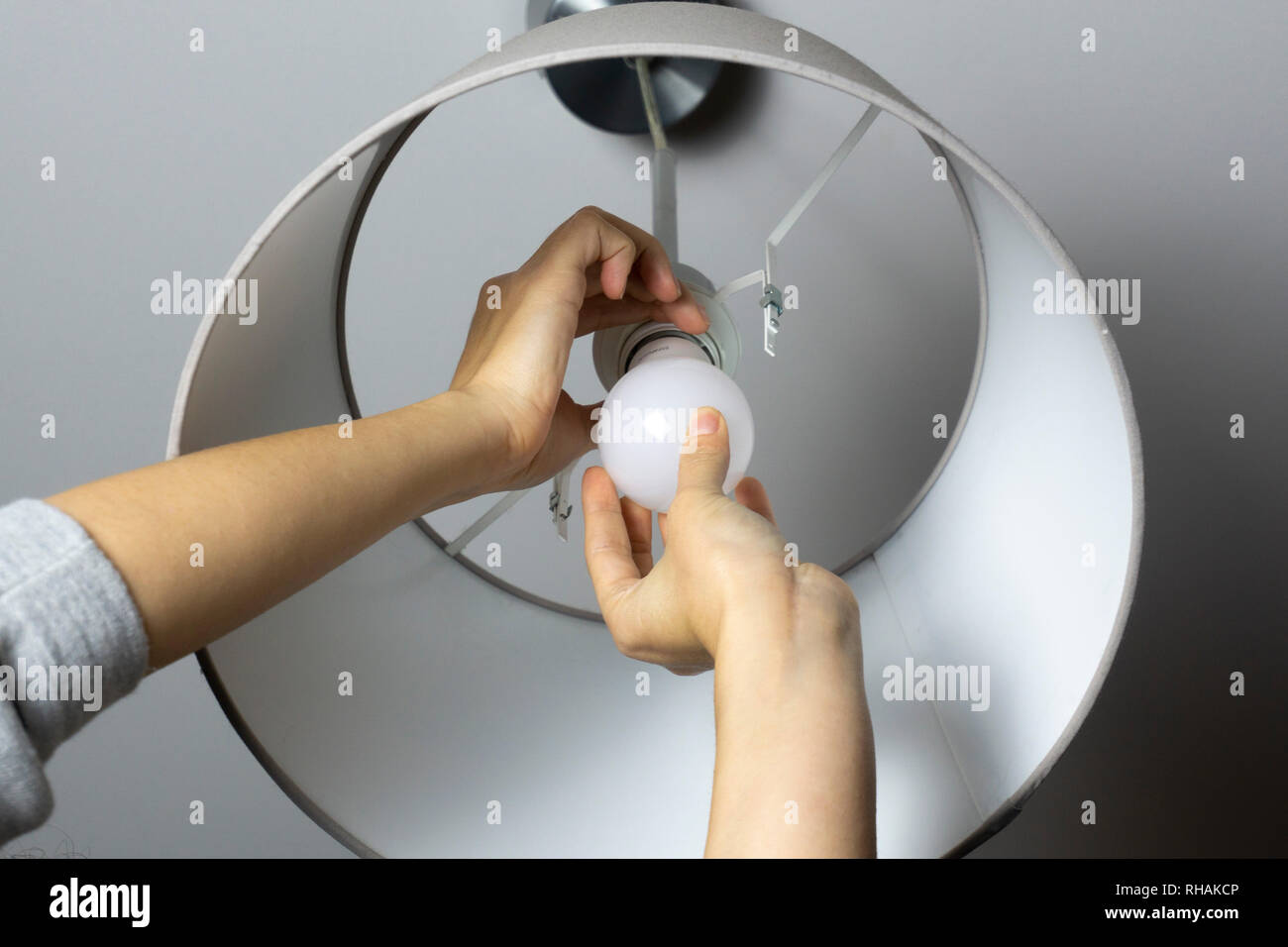 Woman replacing light bulb at home. Power save LED lamp changing Stock Photo